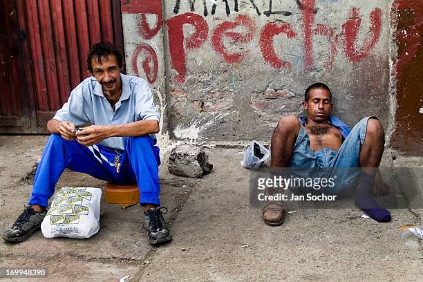 Drunken Colombian garbage recollector sleeps on the street in the slum of Calvario on 23 April 2004 in Cali, Colombia. Calvario, a slum right in the...