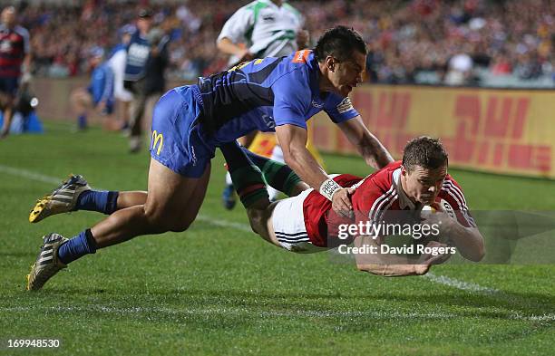 Brian O'Driscoll, the Lions captain, dives over for the second try despite the attention of Sam Christie during the tour match between the Western...