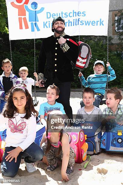 Harald Gloeoeckler poses with kids from kindergarten 'Schneckenhaus' with their new satchels on June 5, 2013 in Berlin, Germany. Gloeoeckler donates...