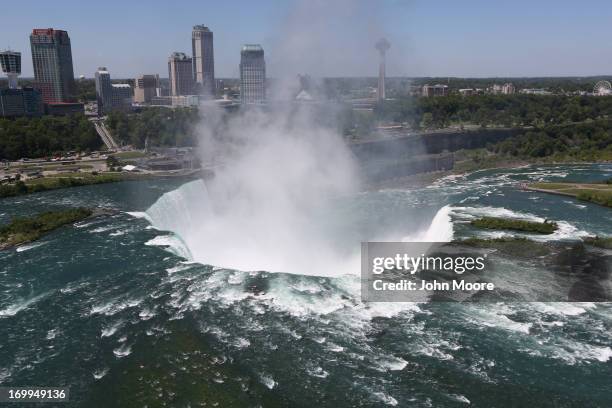 The town of Niagara Falls, Canada is seen past a cloud of mist rising over Horseshoe Falls, the largest of the Niagara Falls on June 4, 2013 across...