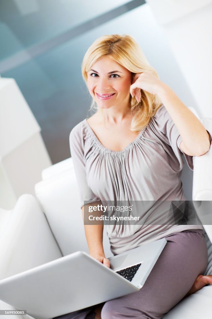 Beautiful young woman using her laptop at home.
