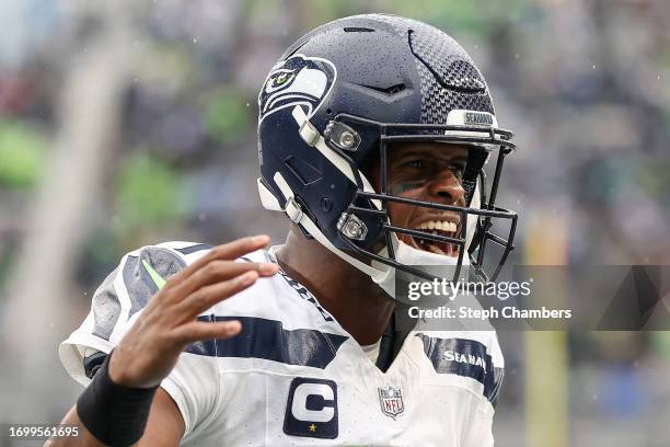 Geno Smith of the Seattle Seahawks reacts after throwing a touchdown pass during the fourth quarter against the Carolina Panthers at Lumen Field on...