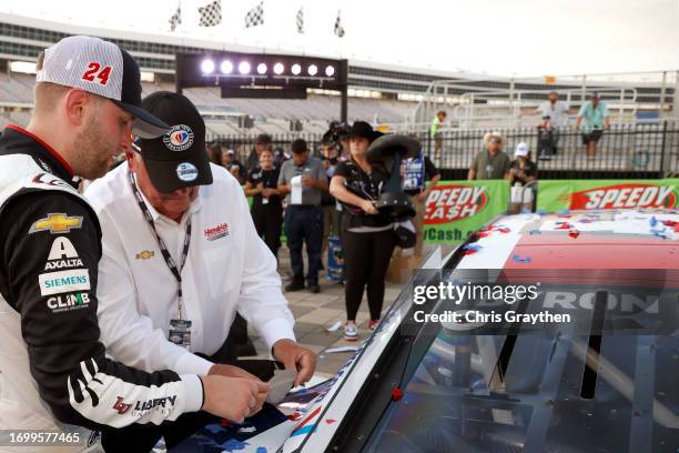 Hall of Famer, Rick Hendrick team owner of Hendrick Motorsport and William Byron place a "Hendrick Motorsports 300th Wins 1984-2023" sticker on the...