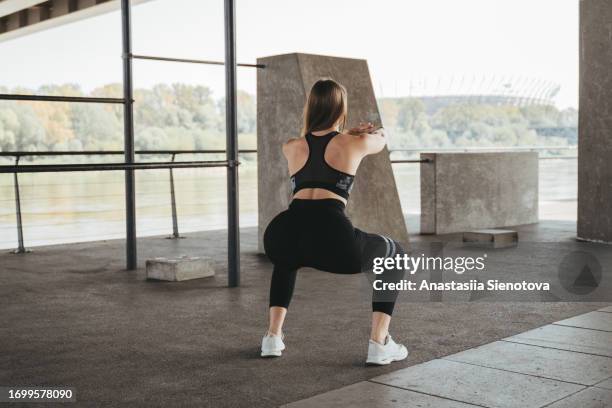 female athlete workout outdoors, rear view - agachar se imagens e fotografias de stock