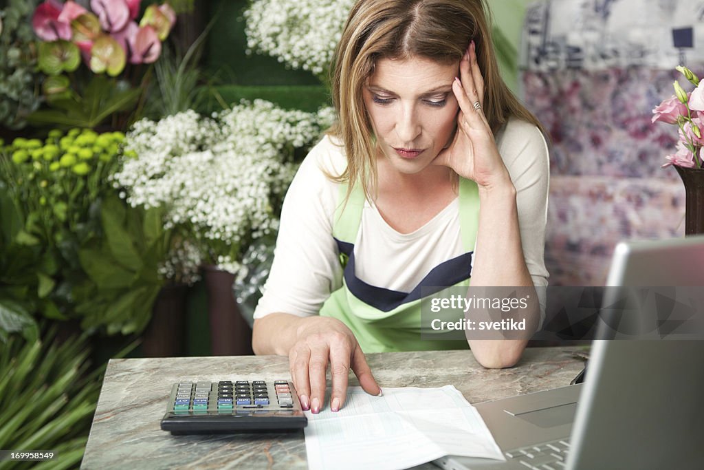 Florist at work paying bills.
