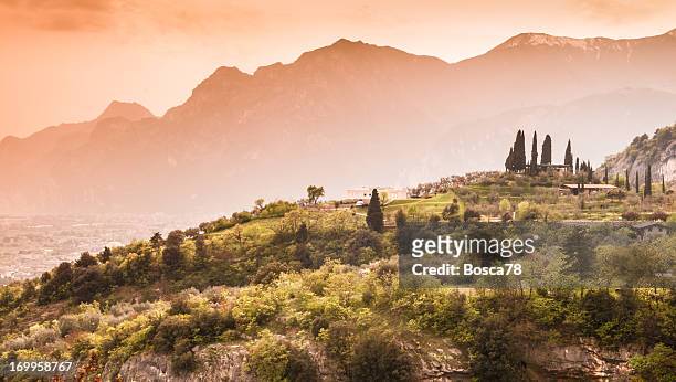 sunset on mountains at north of lake garda, italy - riva del garda stock pictures, royalty-free photos & images