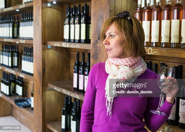 woman is tasting, selling wine in wine store shop - czech republic wine stock pictures, royalty-free photos & images