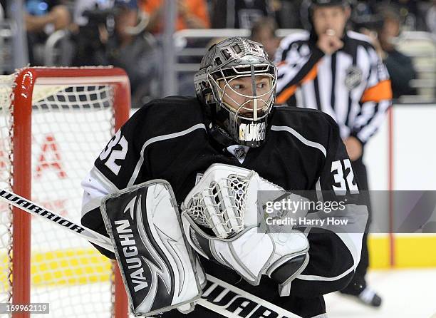 Goaltender Jonathan Quick of the Los Angeles Kings traps the puck between his maks and shoulder pad for the save in the first period of Game Three of...