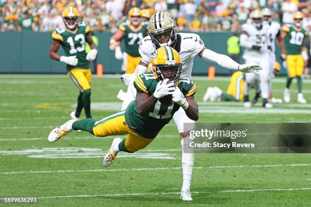 Jayden Reed of the Green Bay Packers catches a pass in front of Alontae Taylor of the New Orleans Saints during a game at Lambeau Field on September...