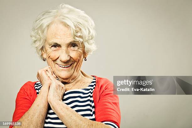 schöne senior frau lächelt in die kamera. - nur seniorinnen stock-fotos und bilder