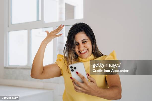 woman receiving good news on smartphone - raffle stock pictures, royalty-free photos & images