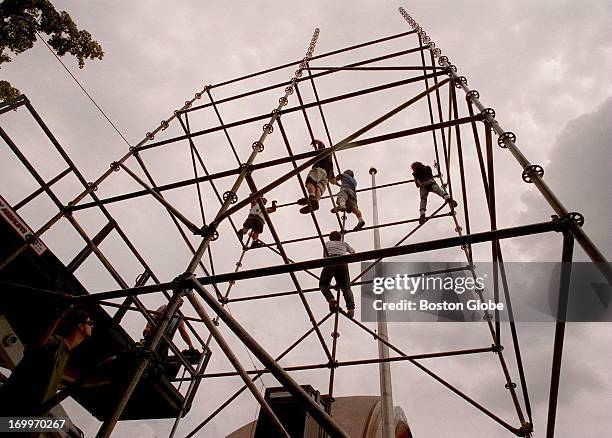 Crew members work to construct a giant scaffolding on Saturday, which will be used in the Fourth of July Boston Pops concert held on the Esplanade.