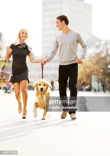 beautiful couple walking the dog. - man with dog fashion stock pictures, royalty-free photos & images