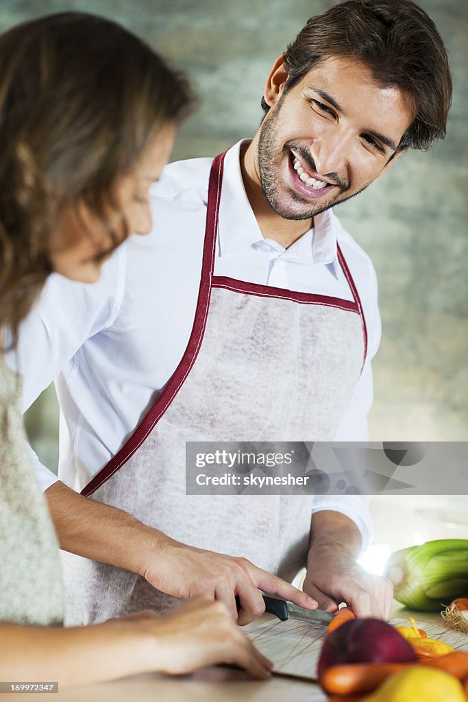 Portrait of smiling young couple preparing lunch together.