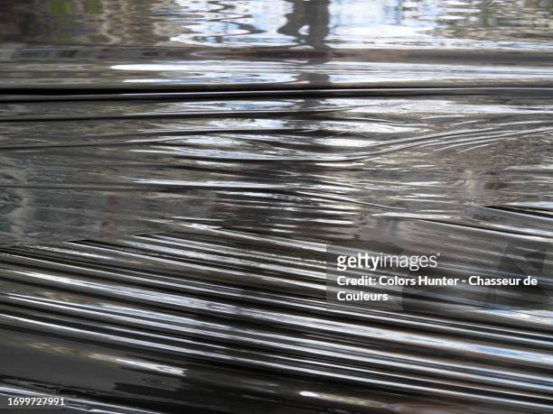 close-up of stretched and wrinkled black plastic on which daylight is reflected in paris, france - photo de film stock pictures, royalty-free photos & images