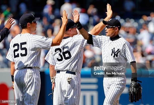Ichiro Suzuki of the New York Yankees celebrates after defeating the Cleveland Indians with teammates Mark Teixeira and Kevin Youkilis at Yankee...