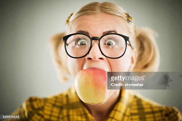 crazy looking woman with an apple in her mouth. - thick white women stock pictures, royalty-free photos & images
