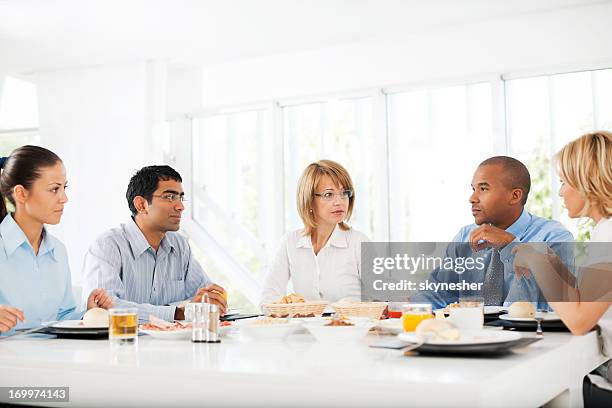 businesspeople having lunch indoors. - breakfast meeting stock pictures, royalty-free photos & images