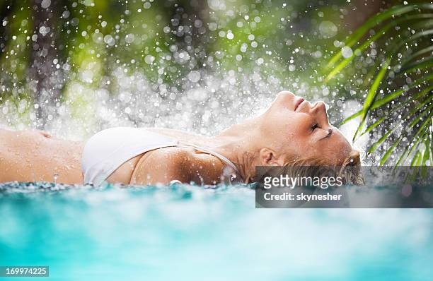 belle femme allongée dans la piscine tropicale. - enjoy monsoon photos et images de collection
