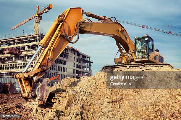 excavator at construction site - digging stockfoto's en -beelden