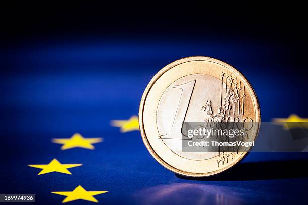 euro coin on european union flag - one euro coin stock pictures, royalty-free photos & images