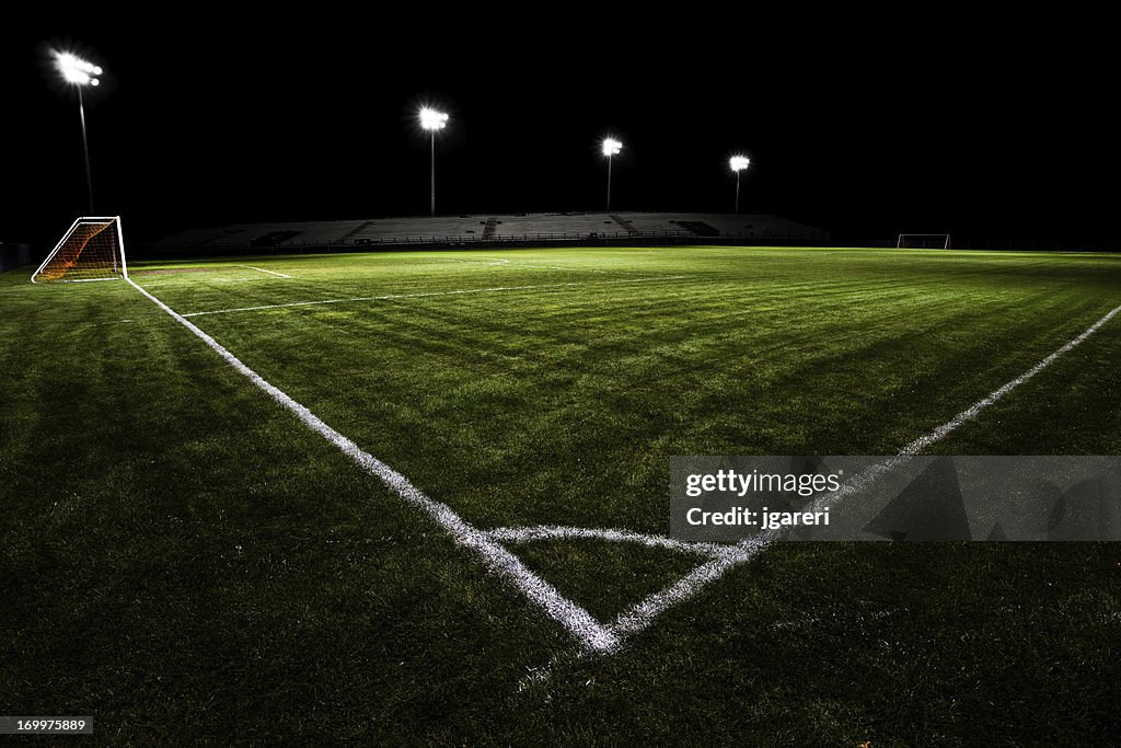 Empty soccer field with floodlights at night