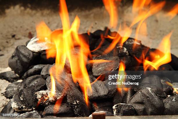 barbecue kohlen mit orange flammen - briketts stock-fotos und bilder