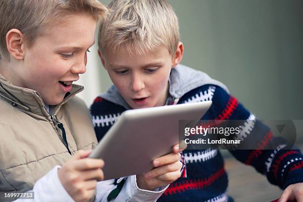 boys with a tablet computer - 10 11 jaar stockfoto's en -beelden