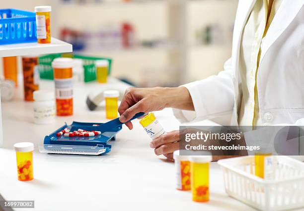 pharmacist filling prescription of pills - prescription drug bottle stock pictures, royalty-free photos & images