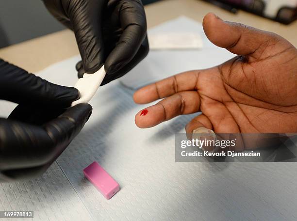 Woman gets an istant HIV/AIDS test inside a moblile clinic of John Wesley Community Health Institute during a health fair sponsored by World Literacy...