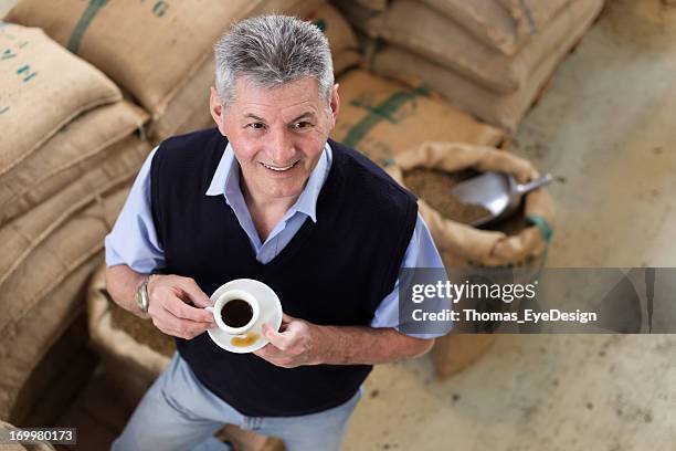 senior adult owner of a coffee roastery - sack stockfoto's en -beelden