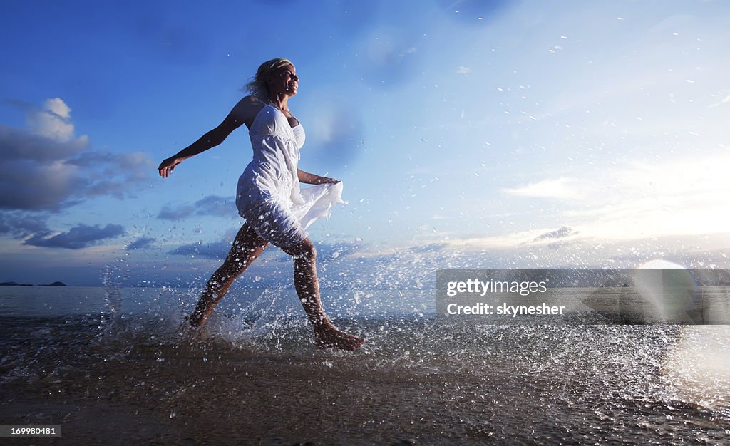 Young lady walking by the sea shore.
