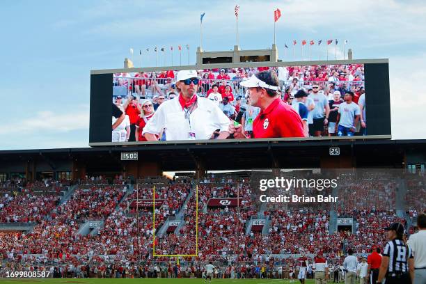 Country music star Toby Keith and former Oklahoma head coach Bob Stoops encourage Oklahoma Sooners fans before a game against the Iowa State Cyclones...