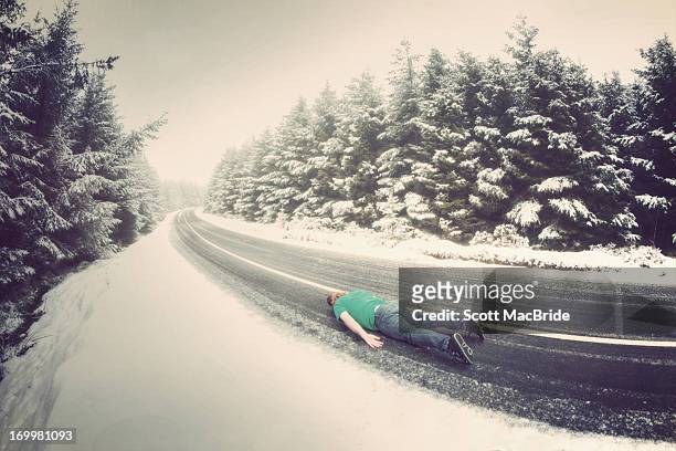 face down on a snowy road - scott macbride stock pictures, royalty-free photos & images