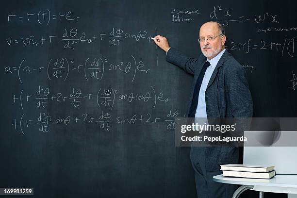 science teacher writting at blackboard physics equation - physics equation stock pictures, royalty-free photos & images