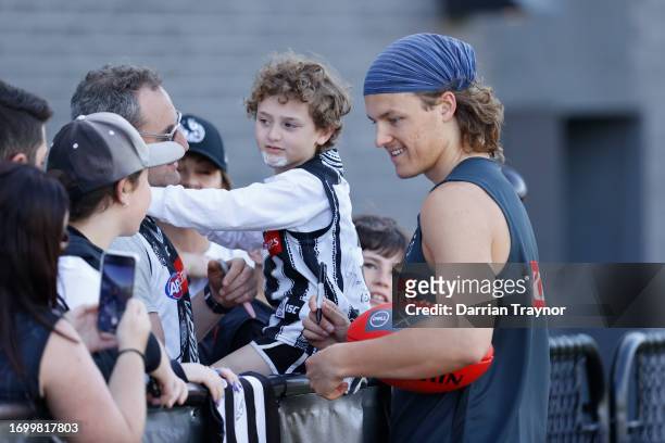 Jack Ginnivan of the Magpies signs an autograph during a Collingwood Magpies AFL training session at AIA Centre on September 25, 2023 in Melbourne,...
