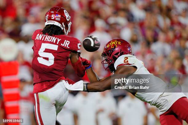 Wide receiver Andrel Anthony of the Oklahoma Sooners loses control of a long pass as he is hit by defensive back T.J. Tampa of the Iowa State...