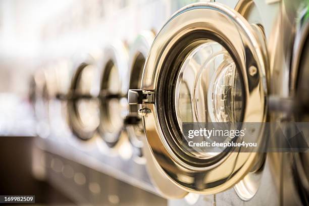 washing machines - clothes washer’s door in a public launderette - coin operated stockfoto's en -beelden