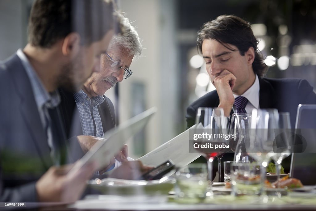 Geschäftsleute, die ein Mittagessen im restaurant und studieren Papierkram