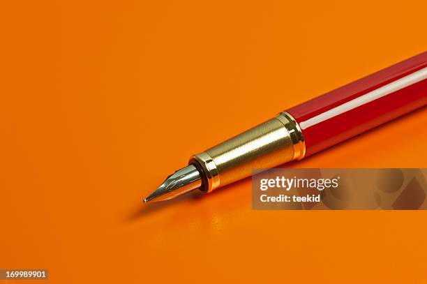 pen on orange background - gastenboek stockfoto's en -beelden
