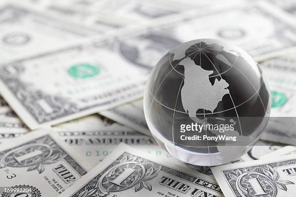 glass globe and money - us paper currency stockfoto's en -beelden