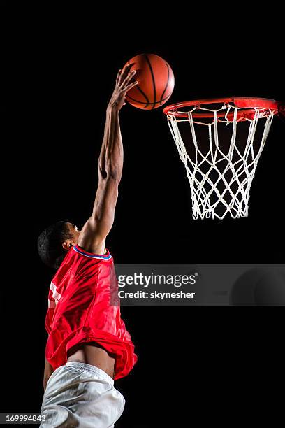 basketball player slam dunking the ball. - basketball hoop stock pictures, royalty-free photos & images