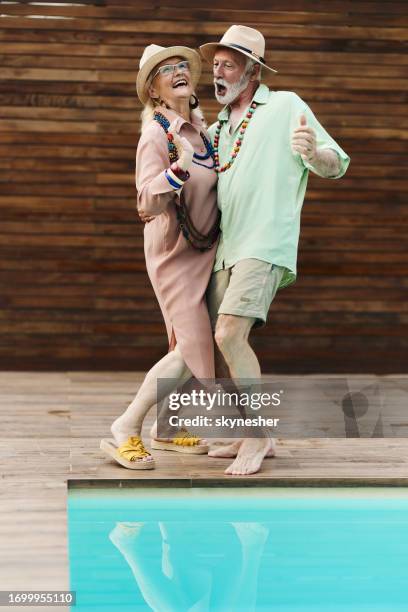 happy mature couple dancing by the pool in the backyard. - man singing stock pictures, royalty-free photos & images