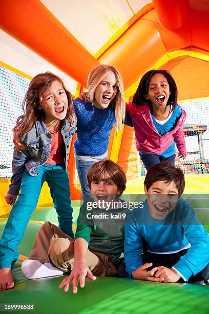 children in bounce house - inflatable playground stock pictures, royalty-free photos & images