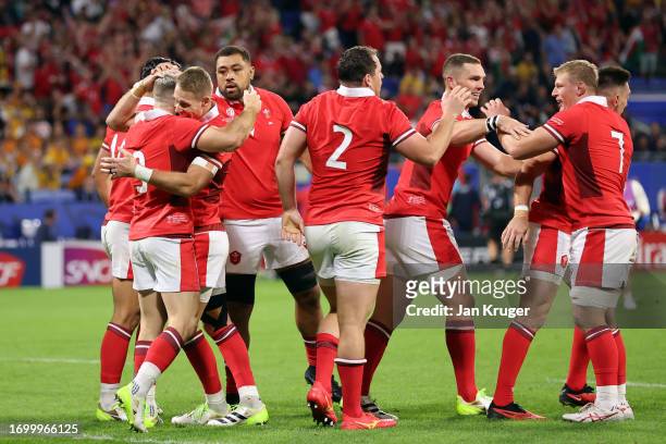 Gareth Davies of Wales celebrates scoring his teams first try with team mates during the Rugby World Cup France 2023 match between Wales and...