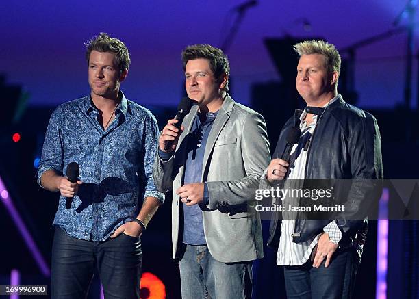 Musicians Joe Don Rooney, Jay DeMarcus and Gary LeVox of Rascal Flatts speak onstage during the 2013 CMT Music awards at the Bridgestone Arena on...