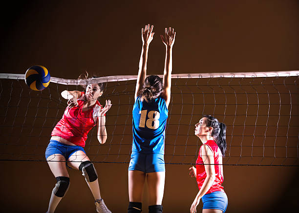 teenage girls playing volleyball. - girls volleyball stock pictures, royalty-free photos & images