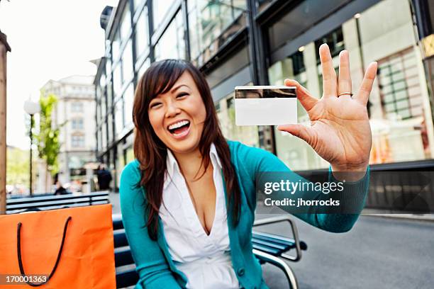 enthusiastic young asian woman with credit card - perks stock pictures, royalty-free photos & images