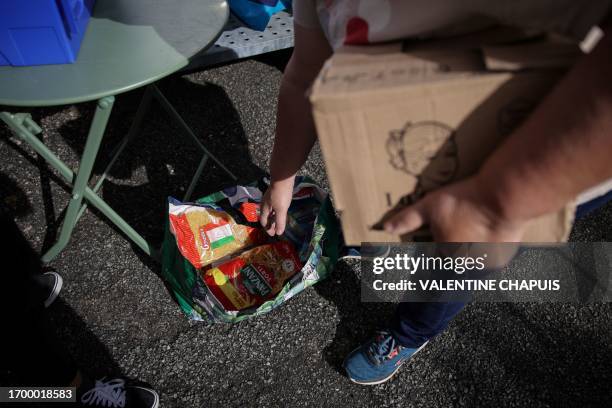 Woman picks up a package sold by the RERTer association , in Limogne-en-Quercy, southwestern France, on September 27, 2023. The RERTer association...