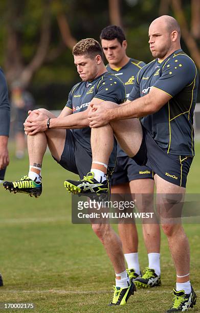 Australian Wallabies flyhalf James O'Connor and hooker Stephen Moore go through their stretching exercises during a team training session in Sydney...